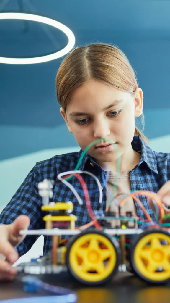 Older child concentrating on a hands-on learning activity involving technology and problem solving.