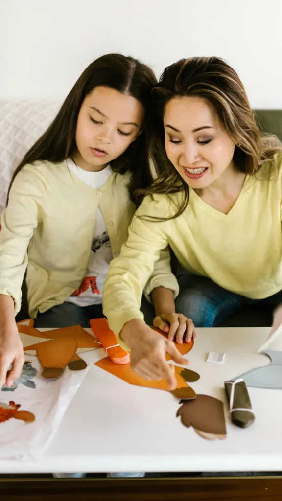 Parent and child working together on a creative activity, with the adult offering support rather than direction.