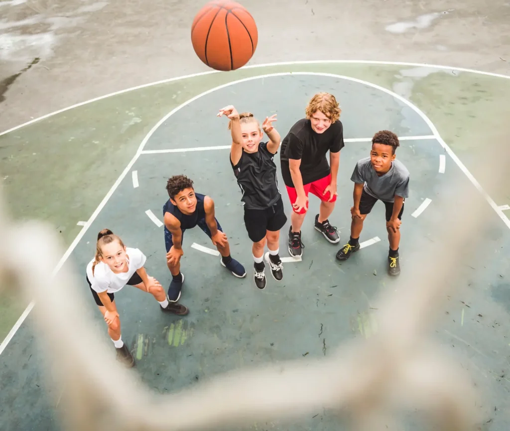 Children playing basketball outdoors during a physical education activity